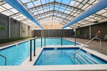 Glass enclosed pool and spa with retractable ceiling